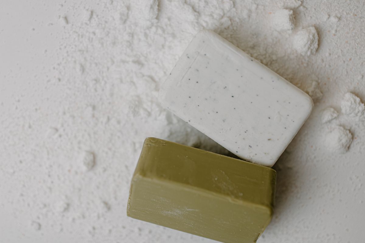 A single handmade soap bar on a dish with dried roses